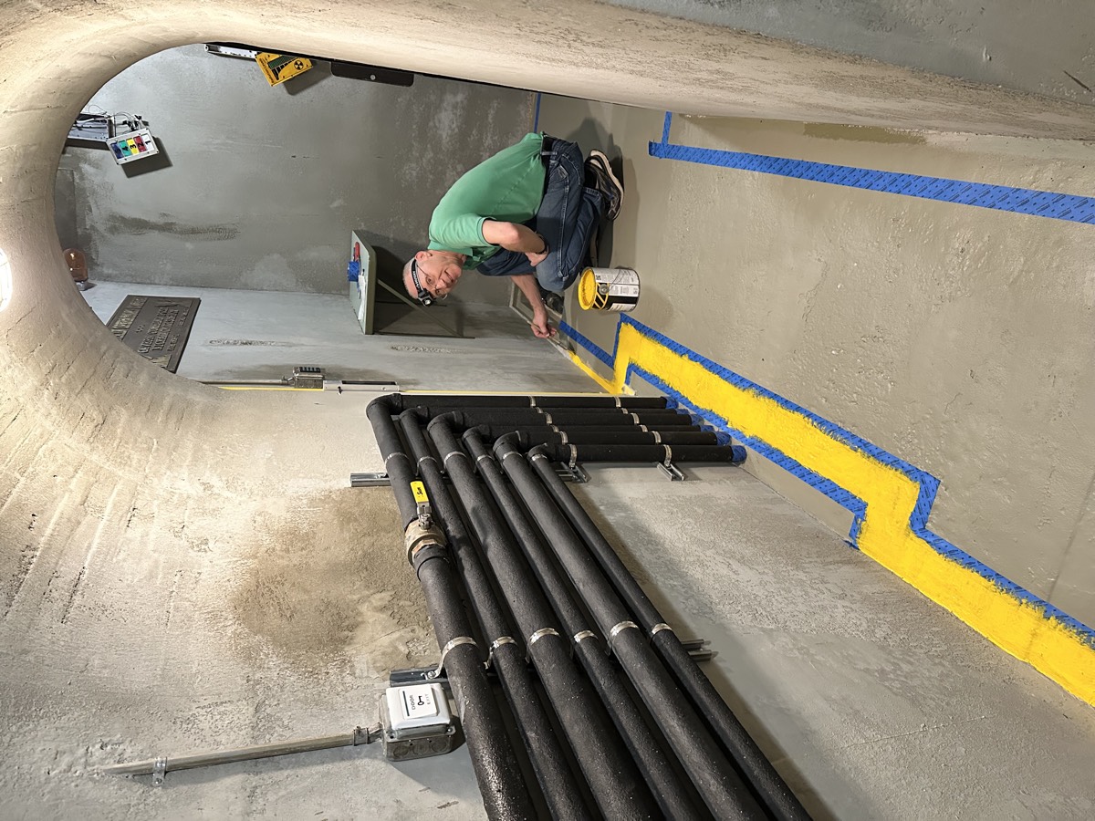 Robert carefully painting yellow safety lines on the floor