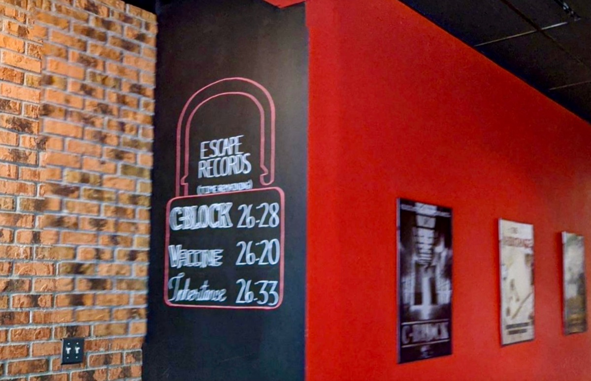 Hand-drawn chalkboard showing escape room records and fastest times at Escape Experience Chattanooga