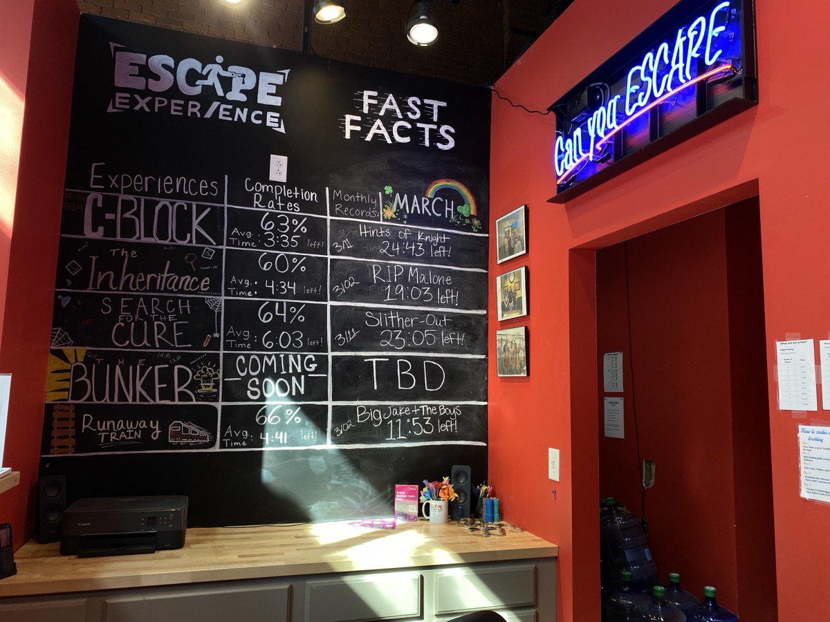 Escape Experience Chattanooga lobby with neon sign and record board